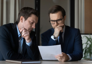 two people looking at a piece of paper