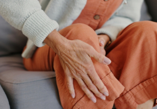 Person holding their knee in pain 