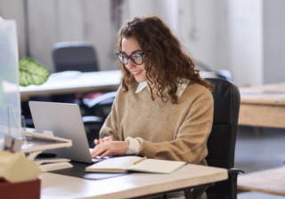 Person sat at a desk on a laptop